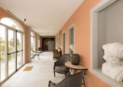 Interior hallway at Casa Dei Padri retreat center with classical sculptures and vintage decor
