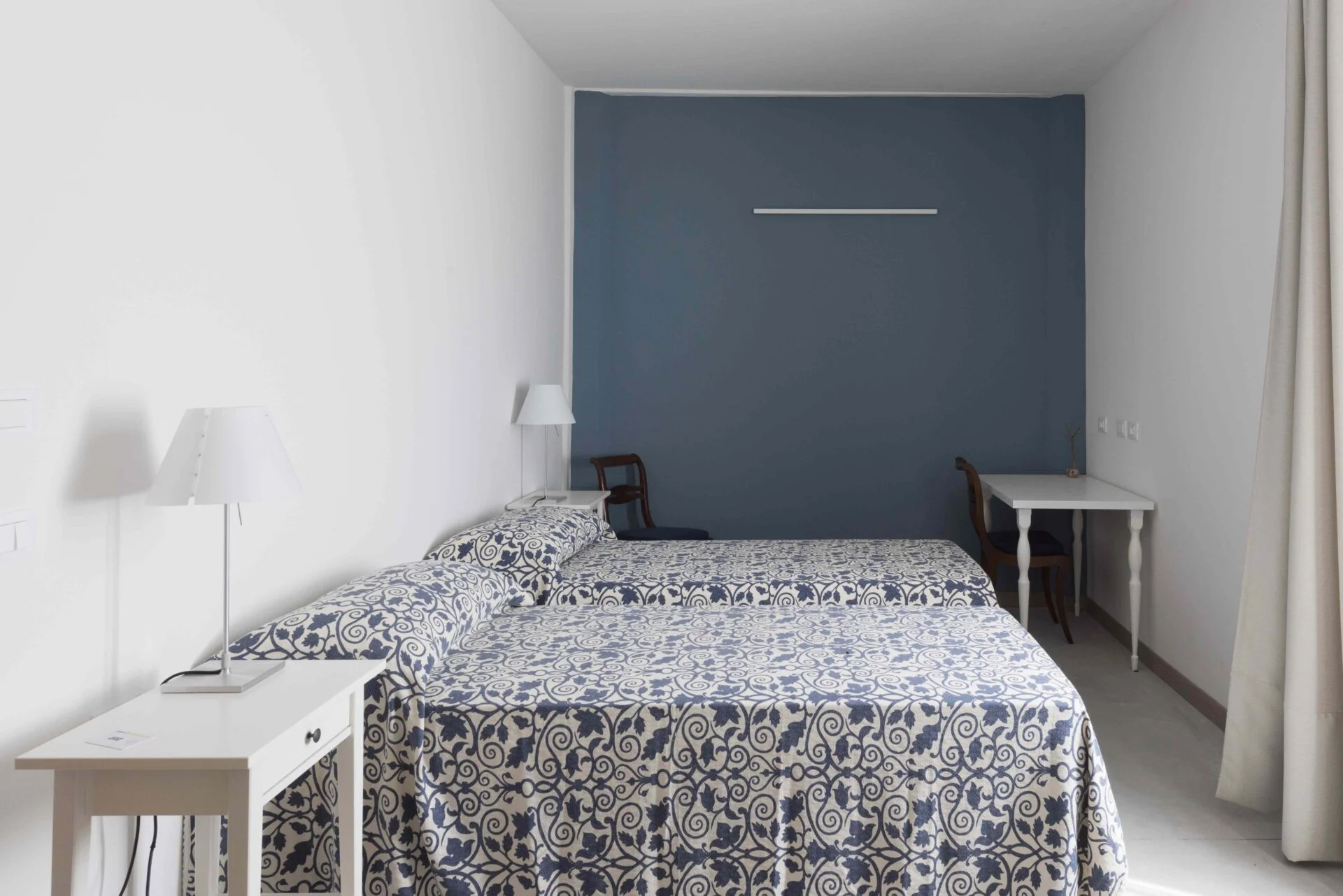 Bright and simple double guest room with twin beds at Casa Dei Padri retreat center