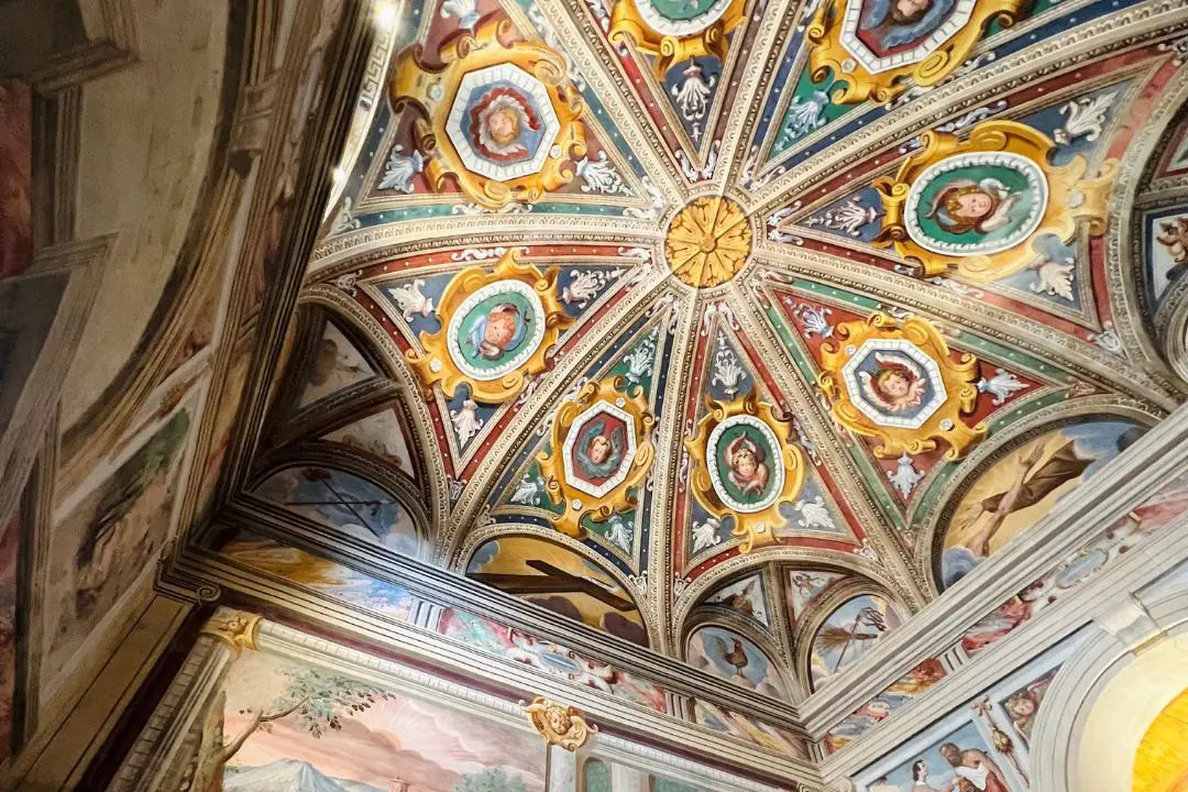 Colorful vaulted fresco ceiling with angelic and saintly figures inside the chapel at Sacro Monte di Orta, Italy